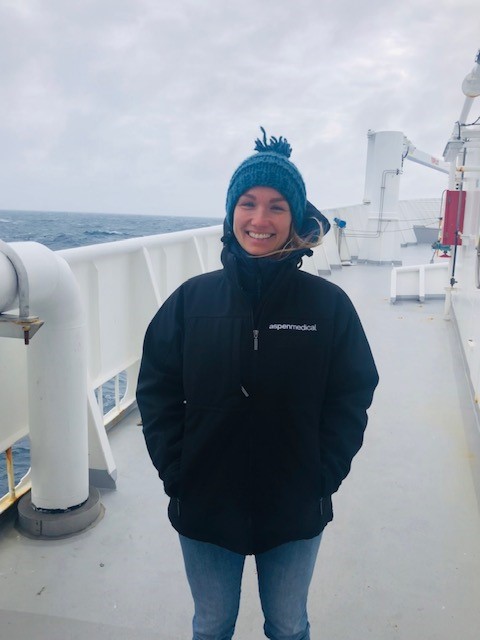 Woman in warm clothing standing on deck of a ship