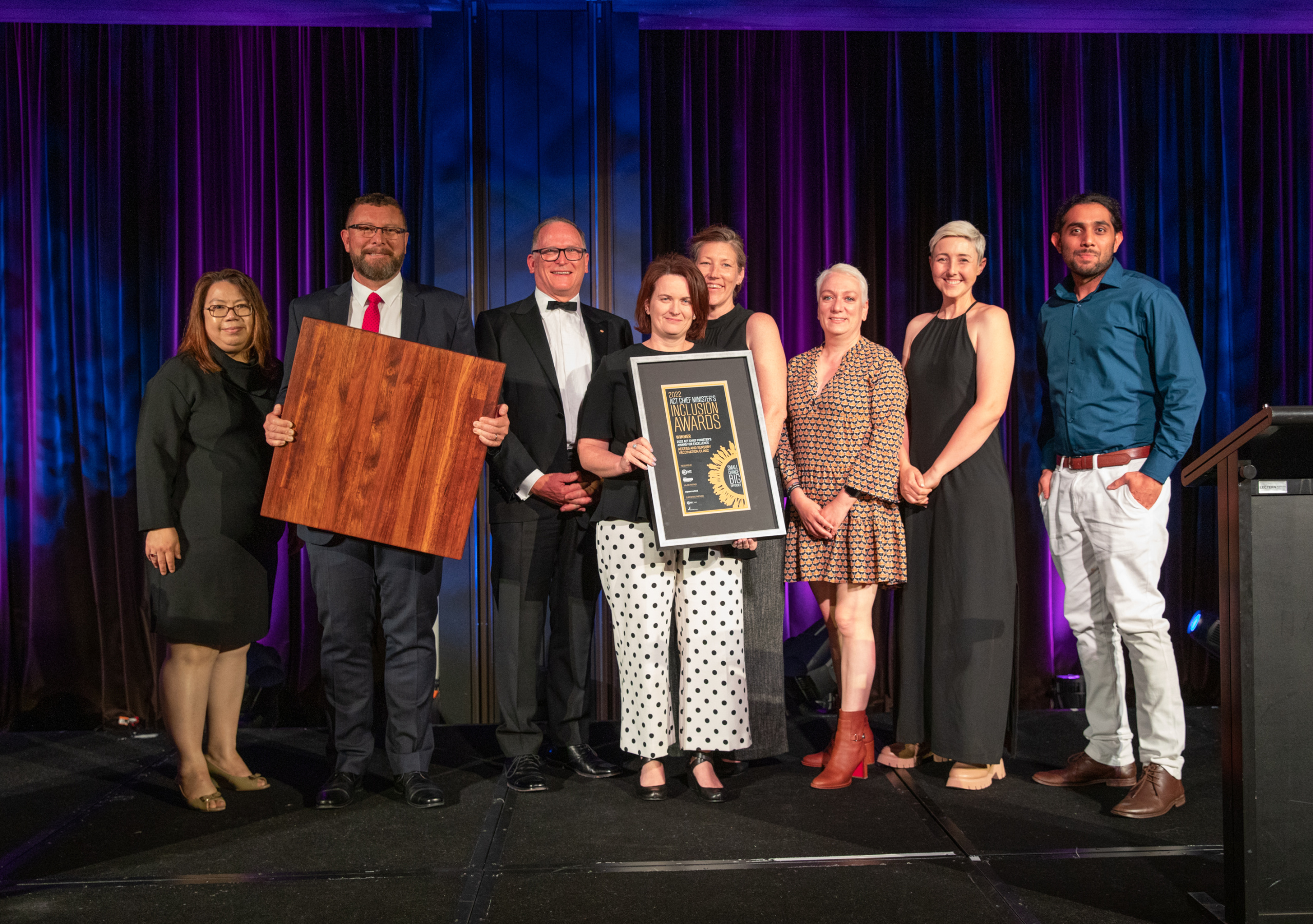 Award-winning team lines up for photo on stage with presenters