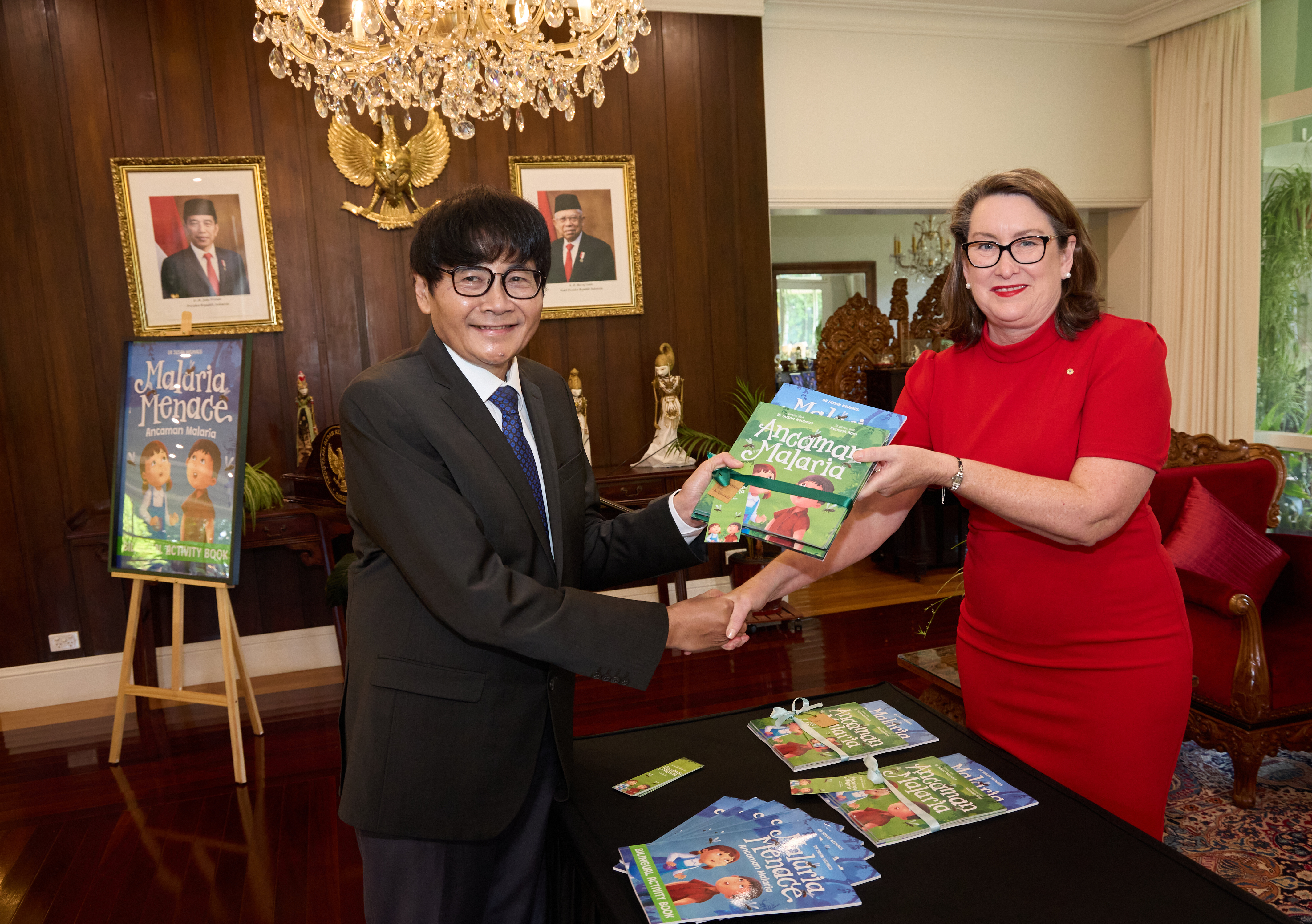 Indonesian Ambassador to Australia accepts a book from the author Dr Susan Neuhaus