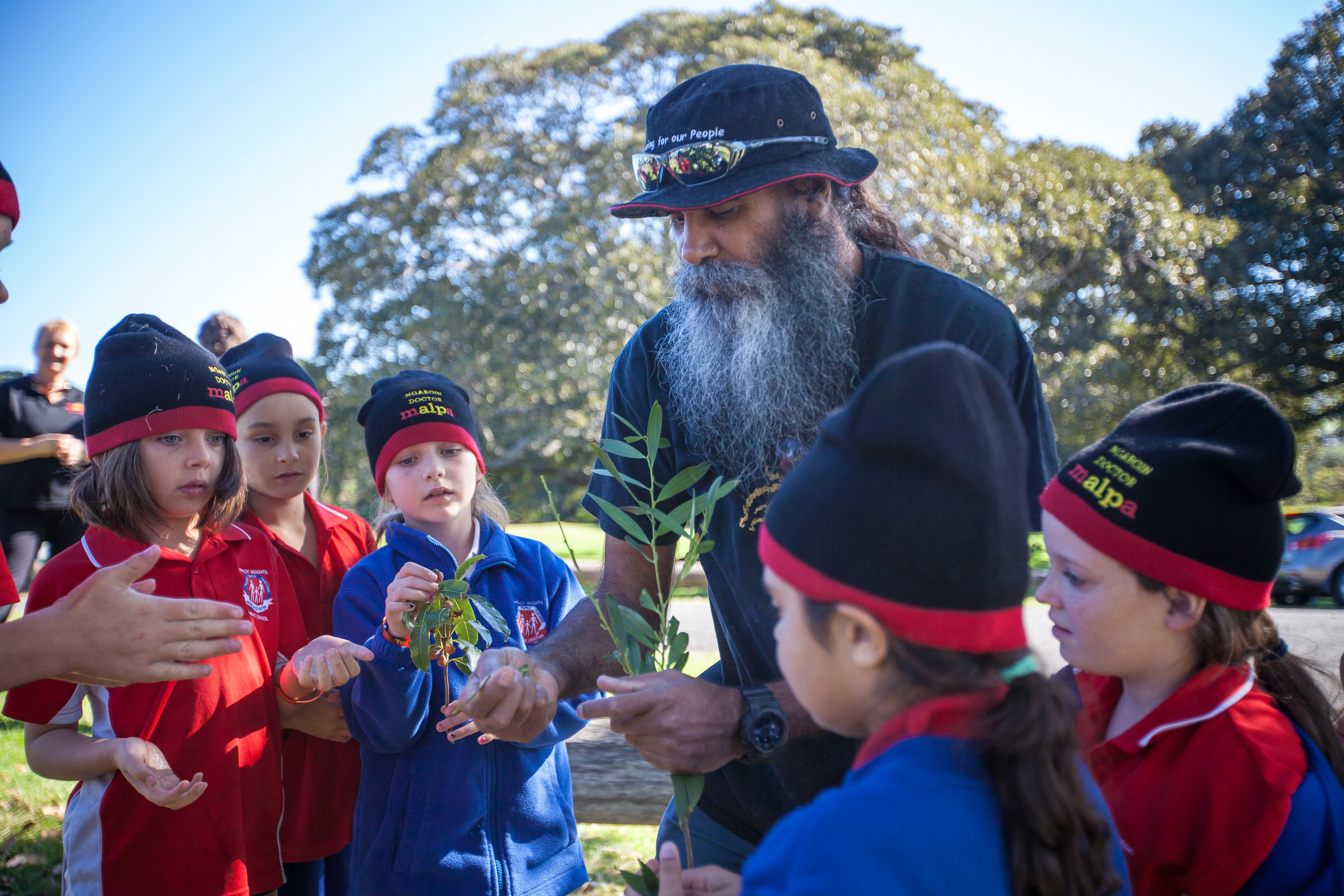 First Nations man talking to children in a circle