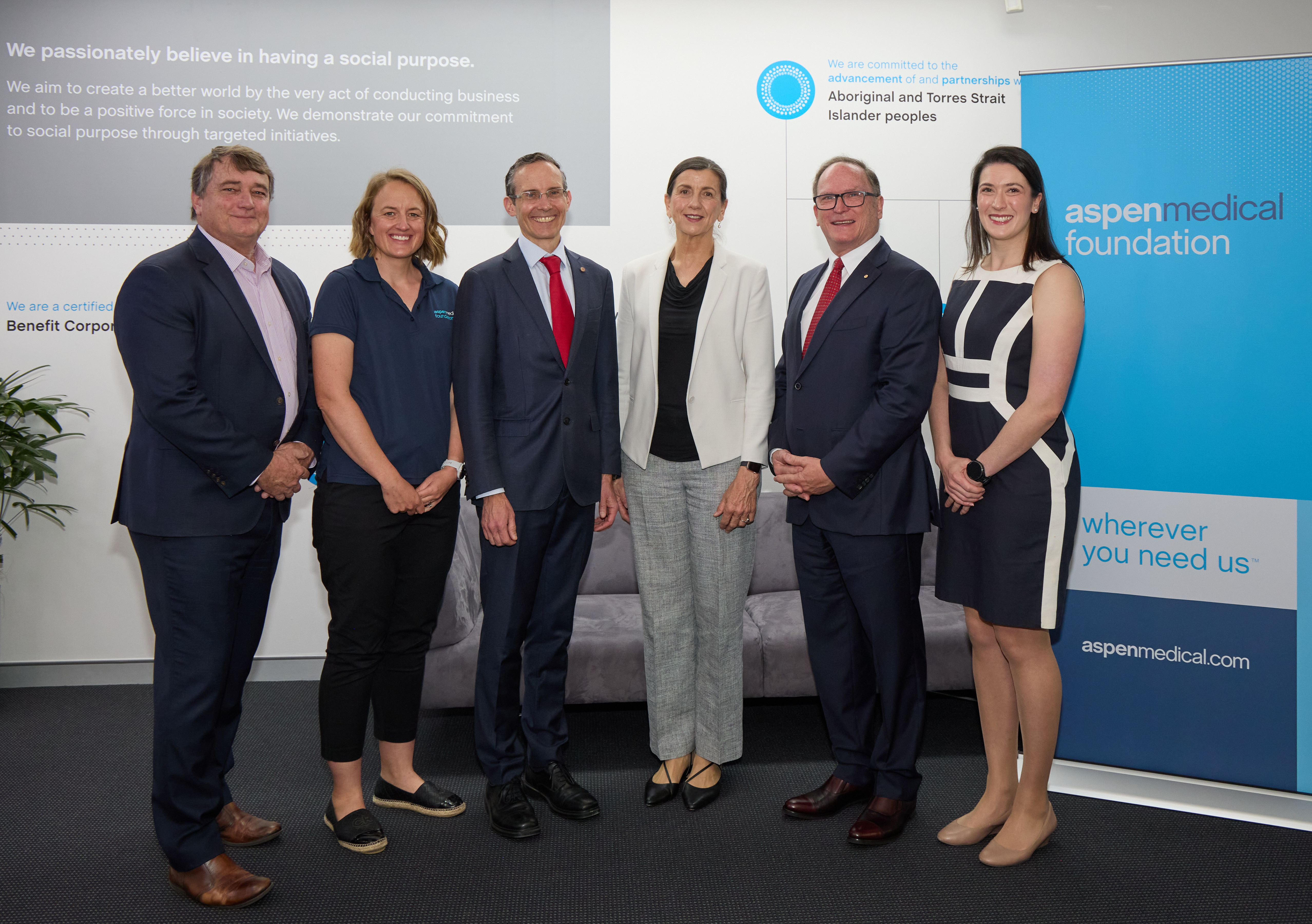 Aspen Medical Foundation team and directors standing with Assistant Minister Andrew Leigh in the Aspen Medical reception area