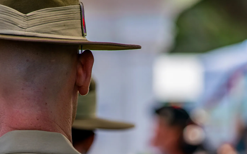 View of the back of an Australian soldiers head, wearing the green uniform hat.