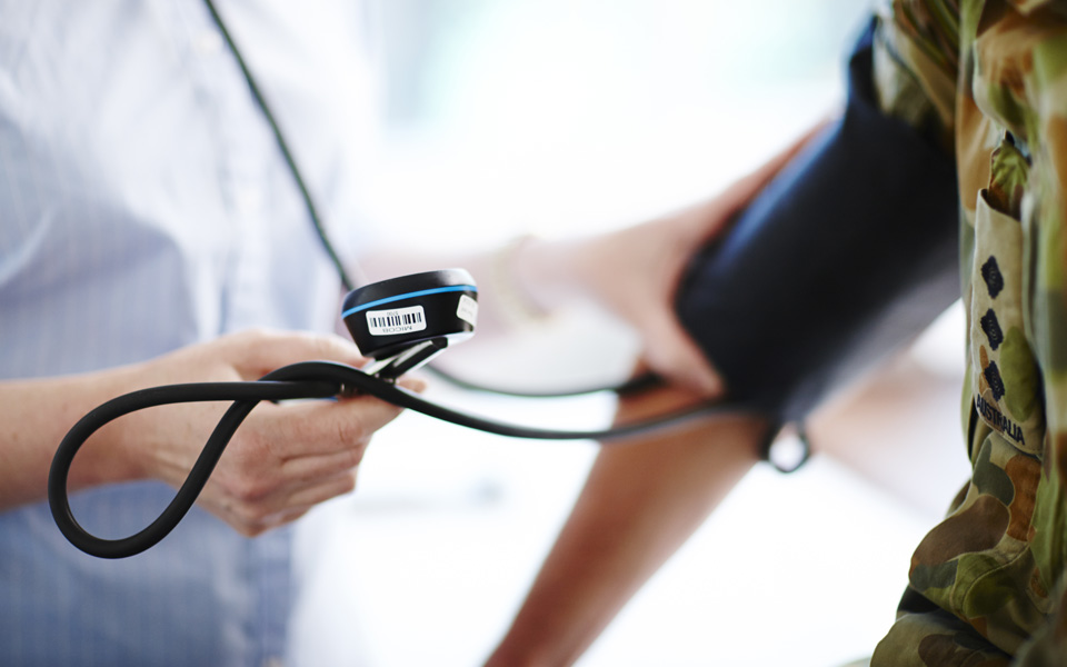 Close up photo of an Aspen Medical clinician taking the blood pressure of an Australian soldier.