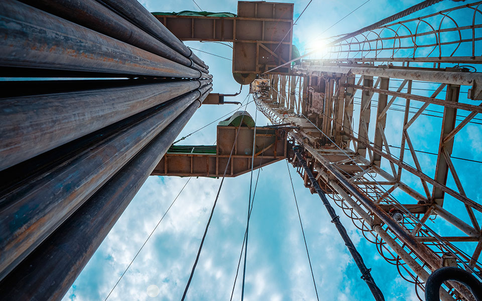 Photo with camera angle looking upward to machinery with the sky behind.