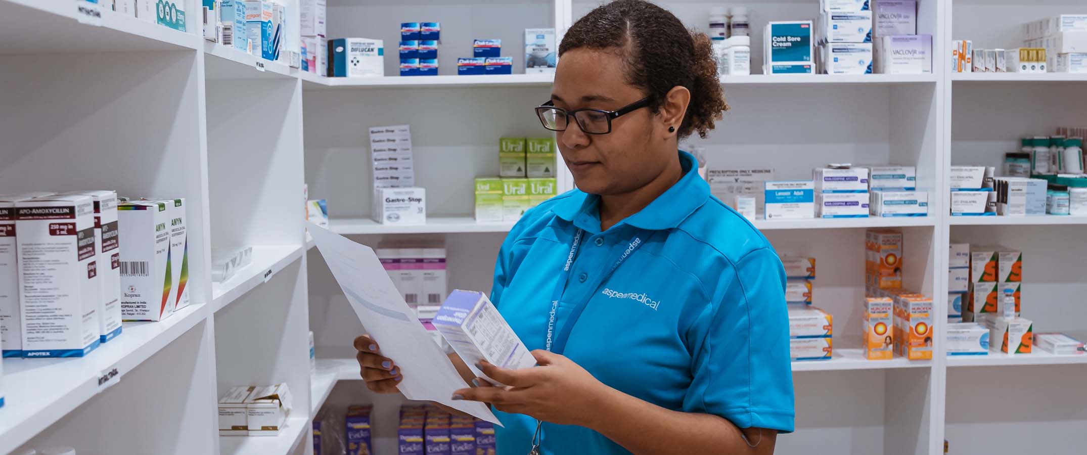 Photo shows a member of Aspen Medical's team in PNG looking through the pharmacy stores.