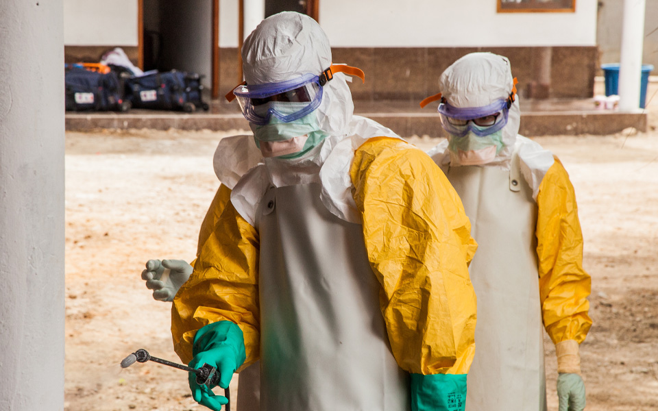 Photo shows two clinical workers in Liberia wearing full safety PPE.