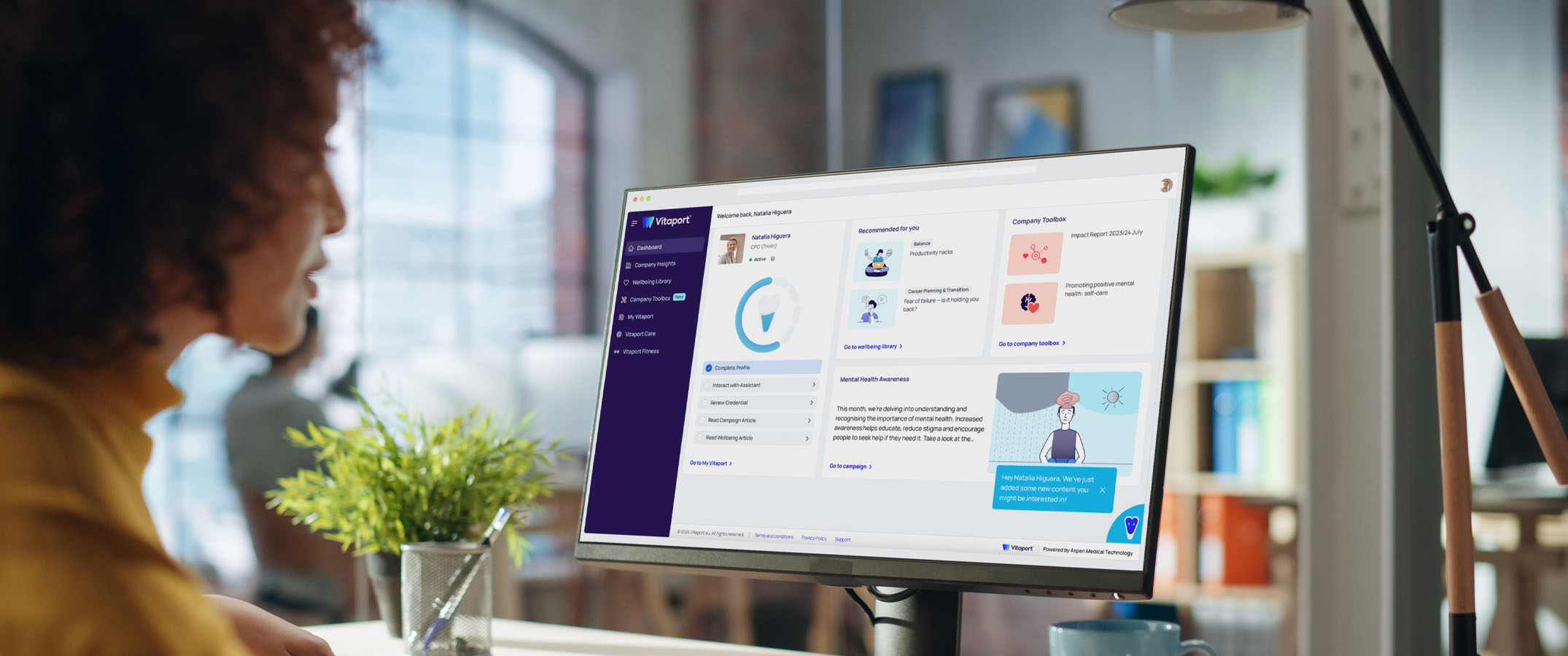 Photo of a woman looking at her Vitaport dashboard on her monitor.
