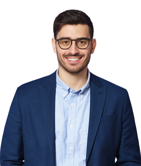 Photo shows a young man with dark hair and glasses dressed smartly with a blue blazer and shirt.