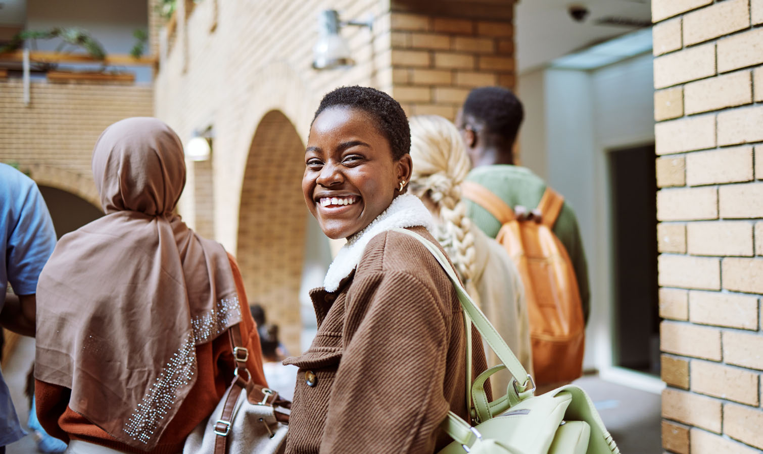 Photo shows a young woman in plain clothes looking back at the camera and smiling.