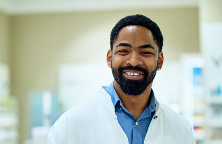 Photo shows a male clinician in a white lab coat holding a clip board.