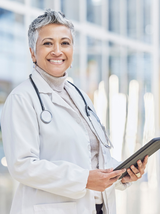 Photo shows a senior female clinician with short grey hair.