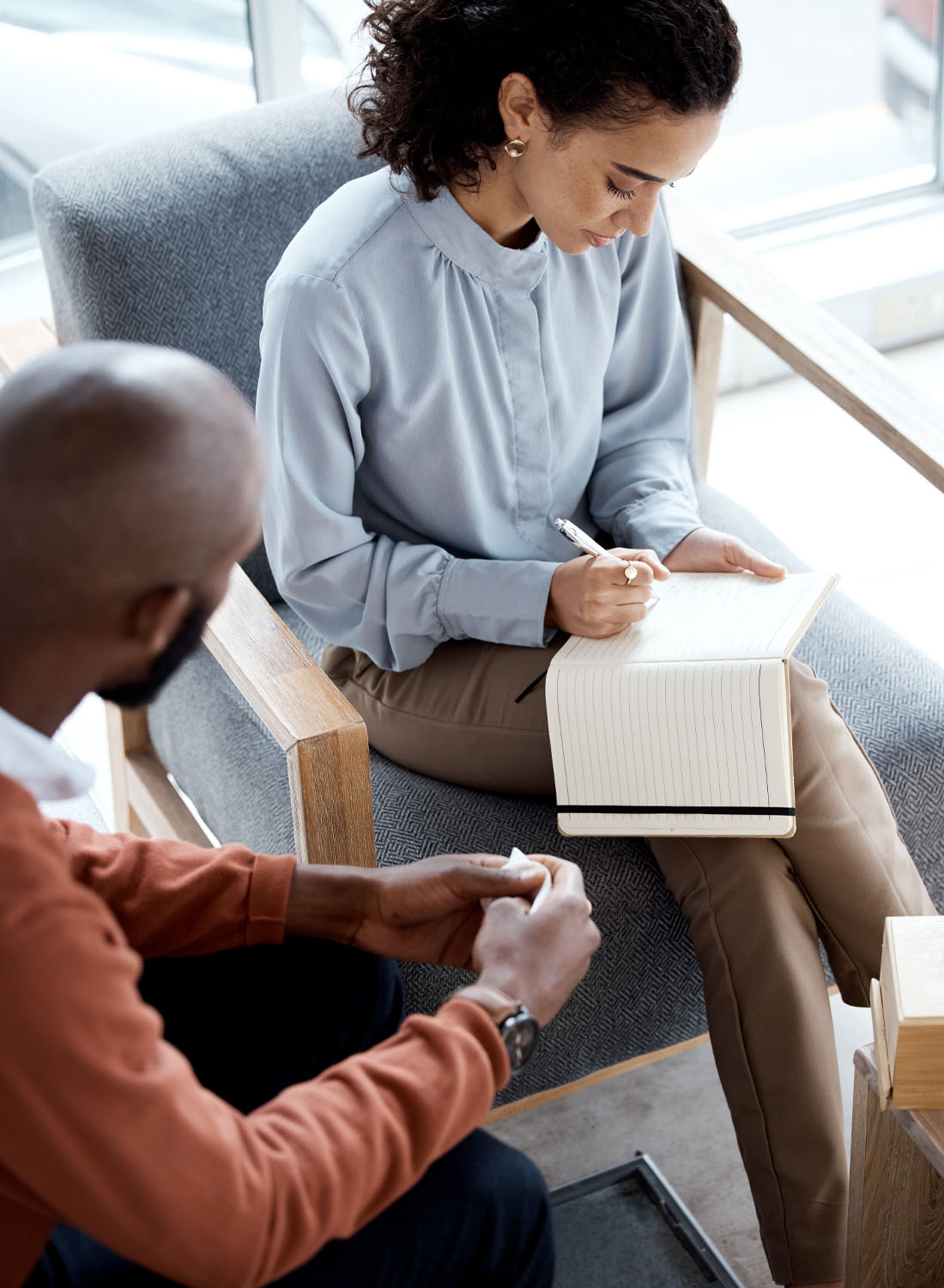 Photo shows a woman and man sitting together, having a meeting.
