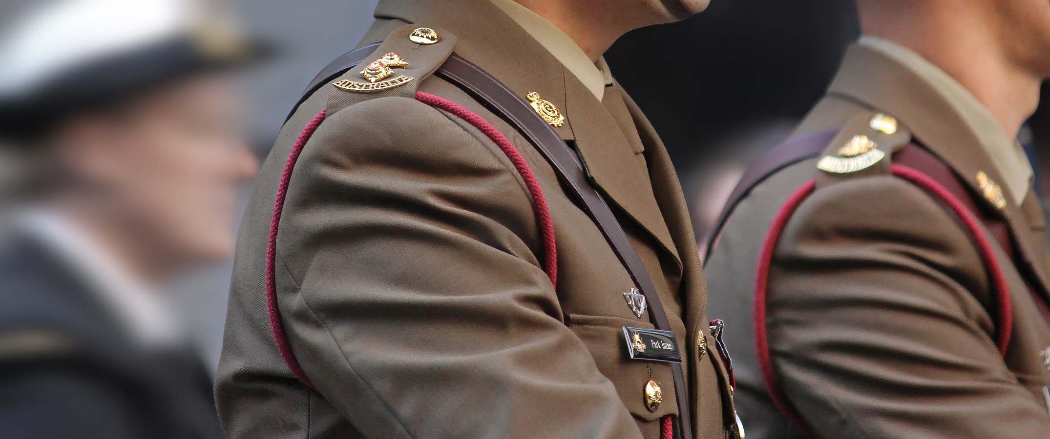 Photo shows a close up of the shoulders of Australian soldiers marching.