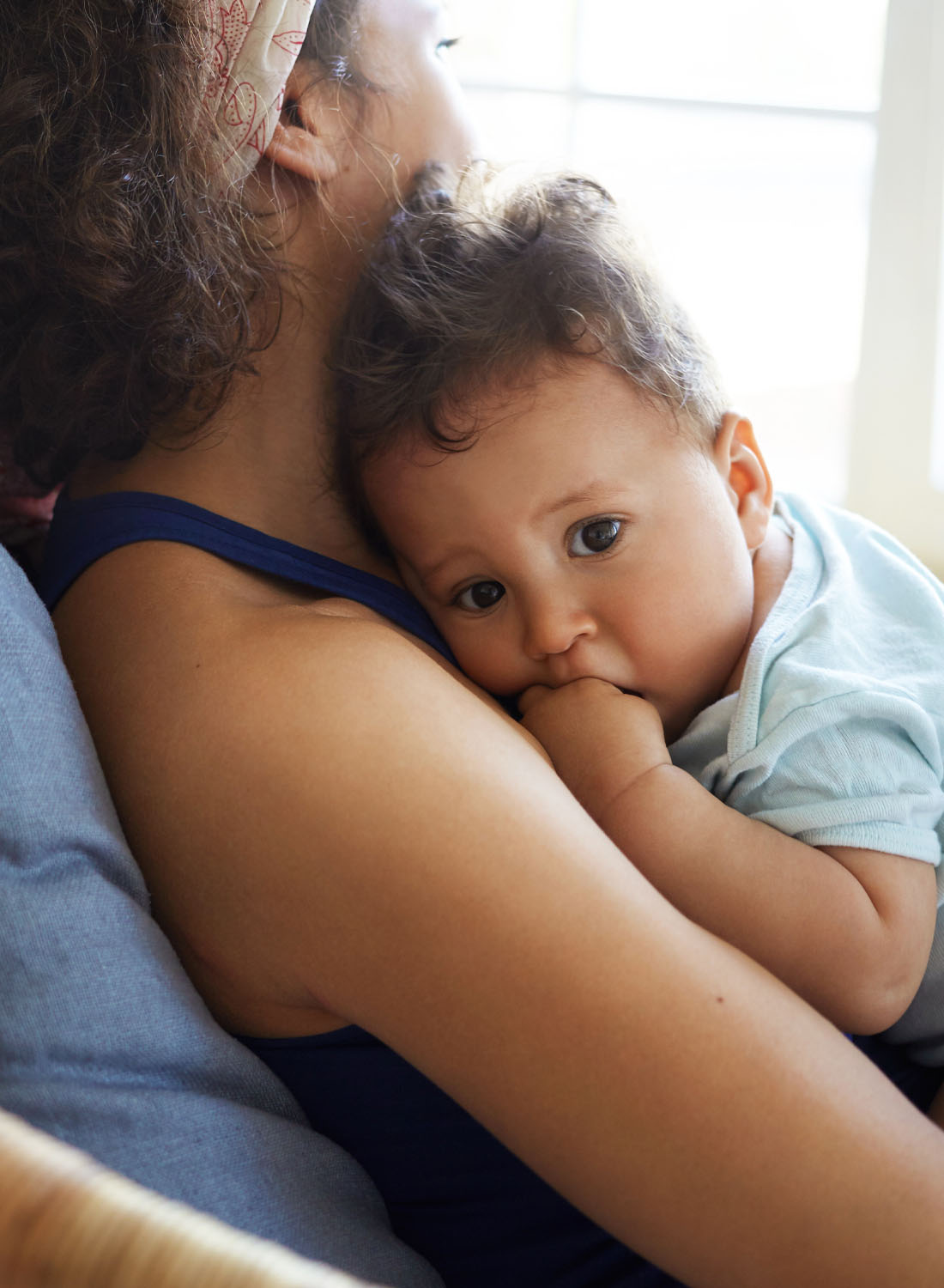 Photo shows a young boy slight on his mothers chest.