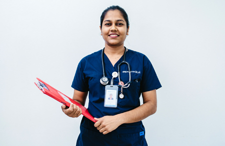 Photo shows an Aspen Medical Fijian nurse holding a clipboard and wearing scrubs.
