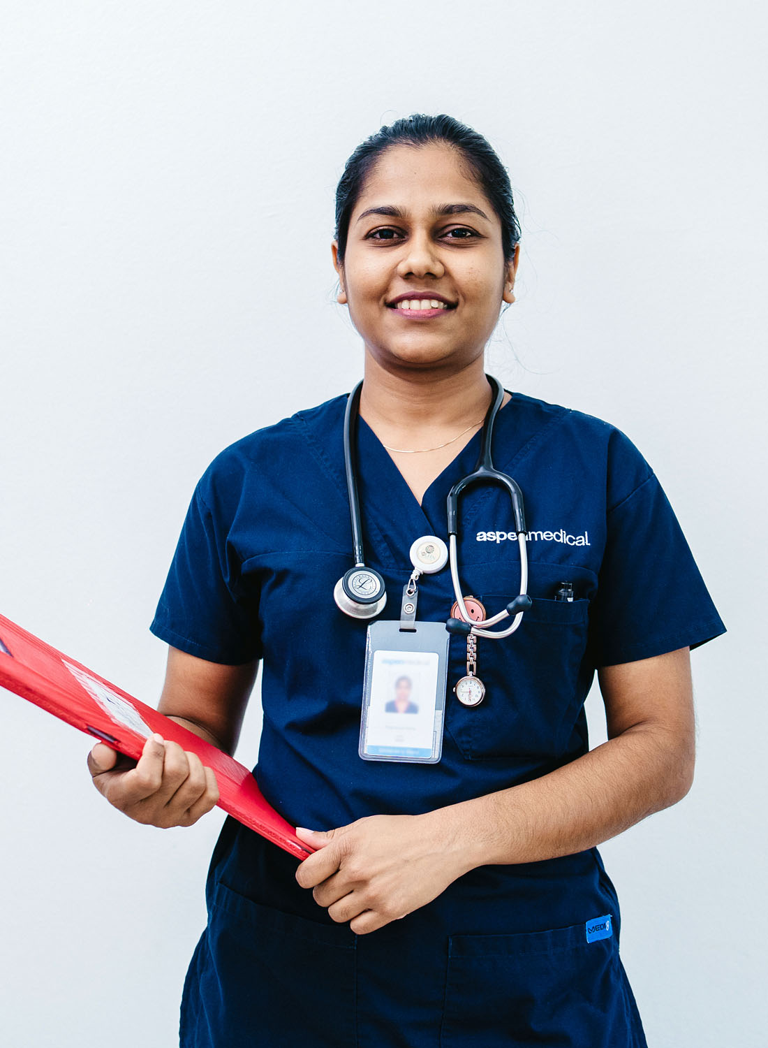 Photo shows an Aspen Medical Fijian nurse holding a clipboard and wearing scrubs.