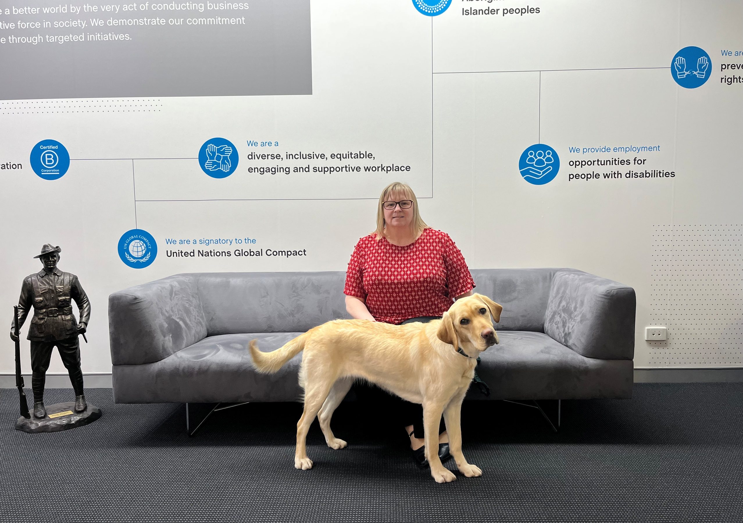Woman sitting on a couch with a dog standing in front of her