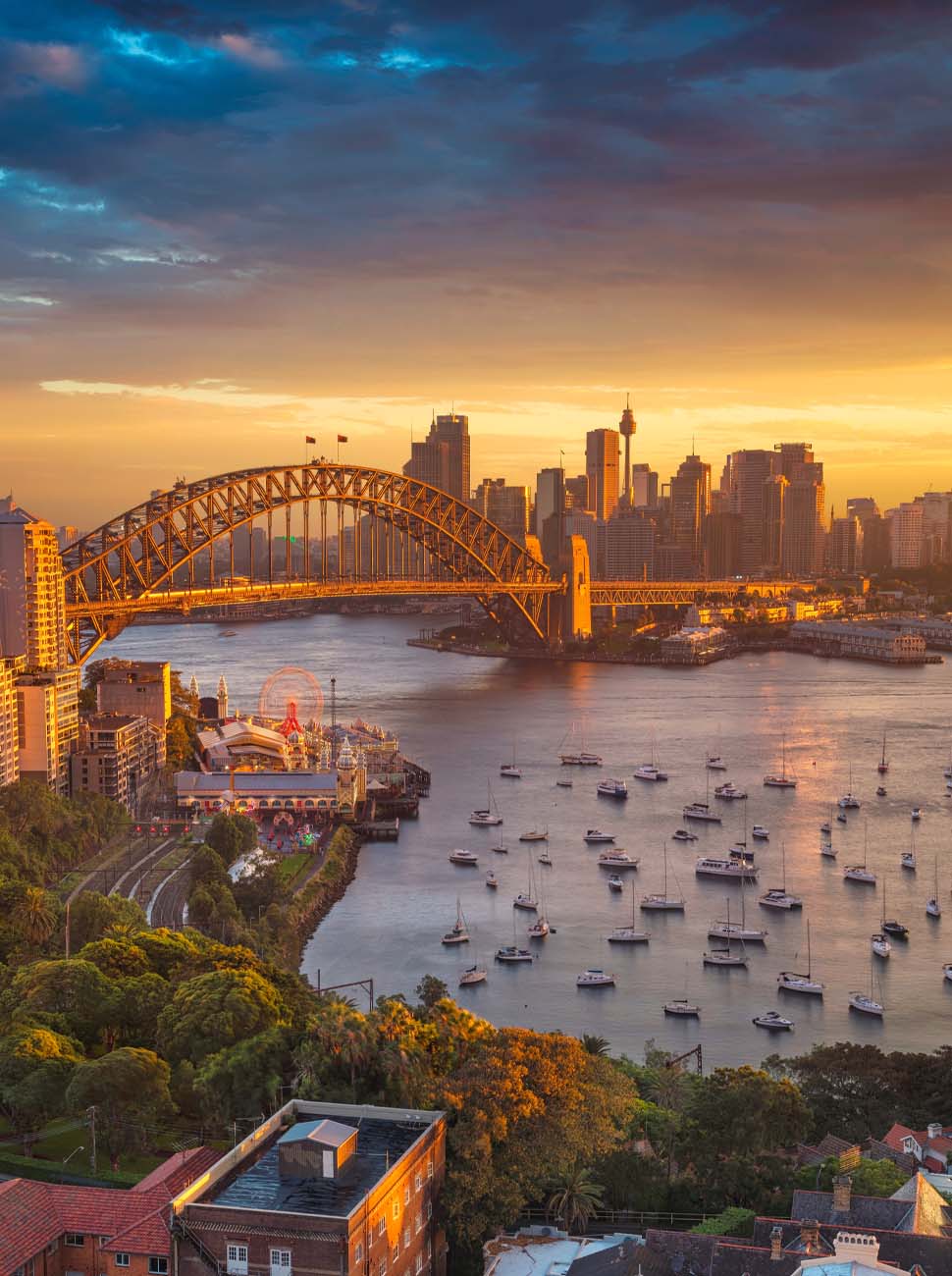 Photo shows Sydney Harbour Bridge and surrounds at sunset.