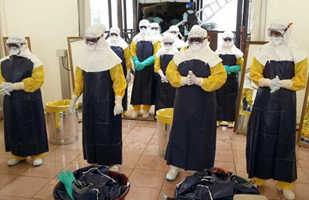 Photo shows Aspen Medical clinicians in full PPE during Ebola crisis.