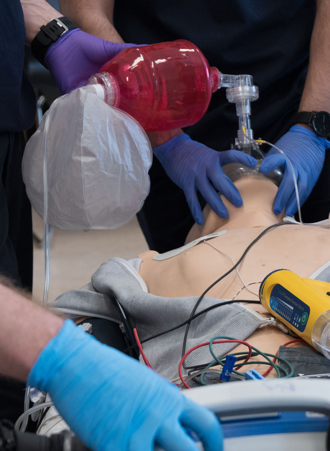 Photo shows someone being trained to use an air device on a dummy.