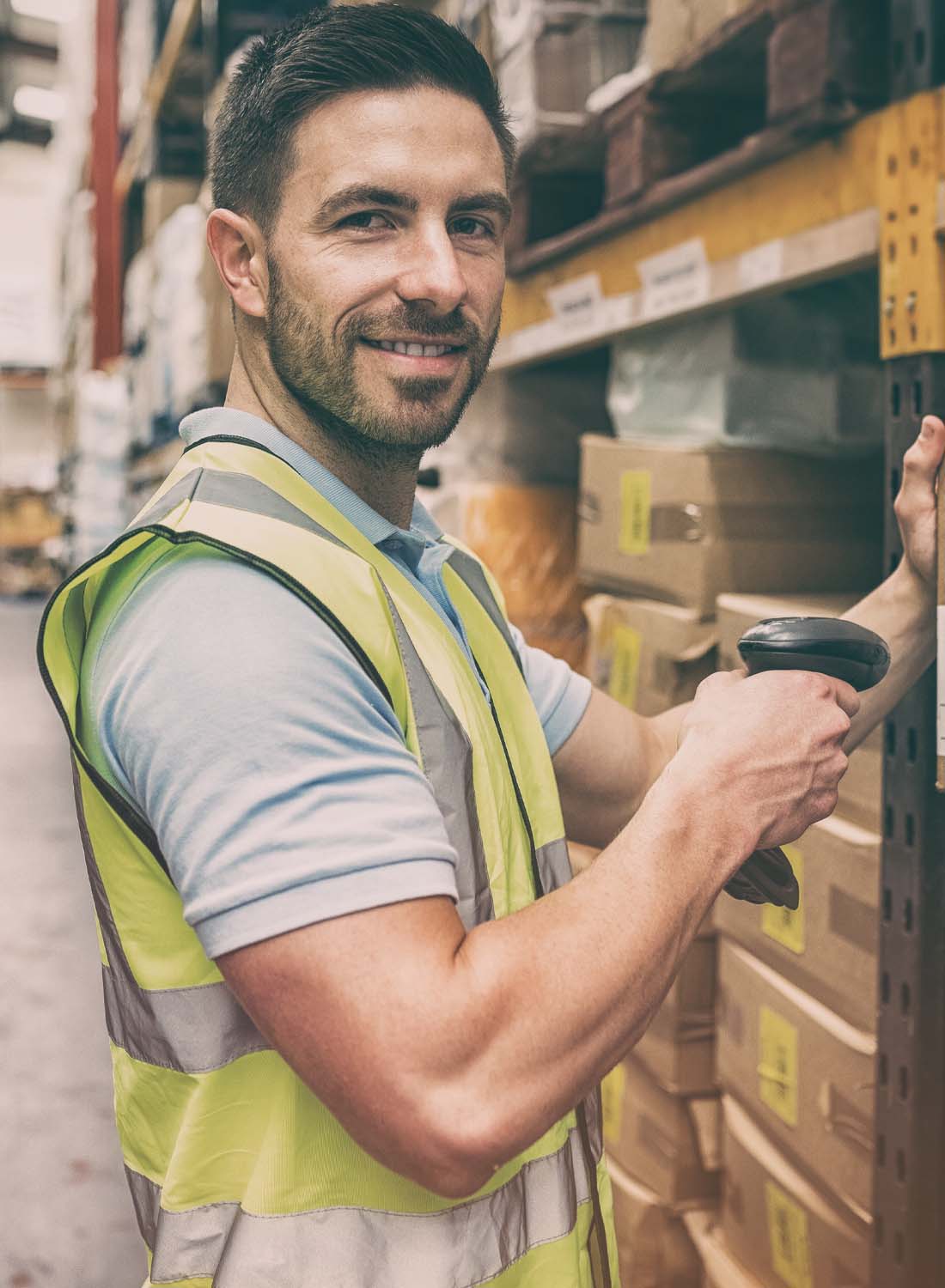 Image shows a man working in a warehouse wearing high vis.
