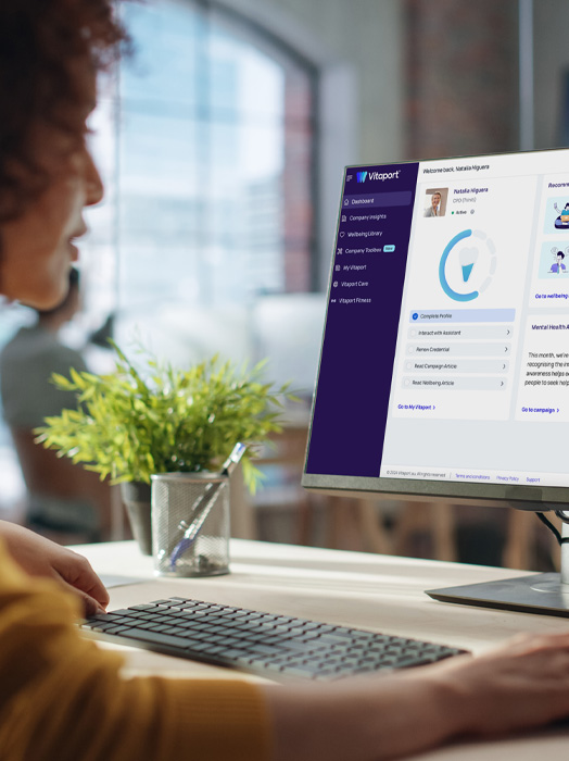 Photo shows a woman accessing Vitaport on her desktop computer.