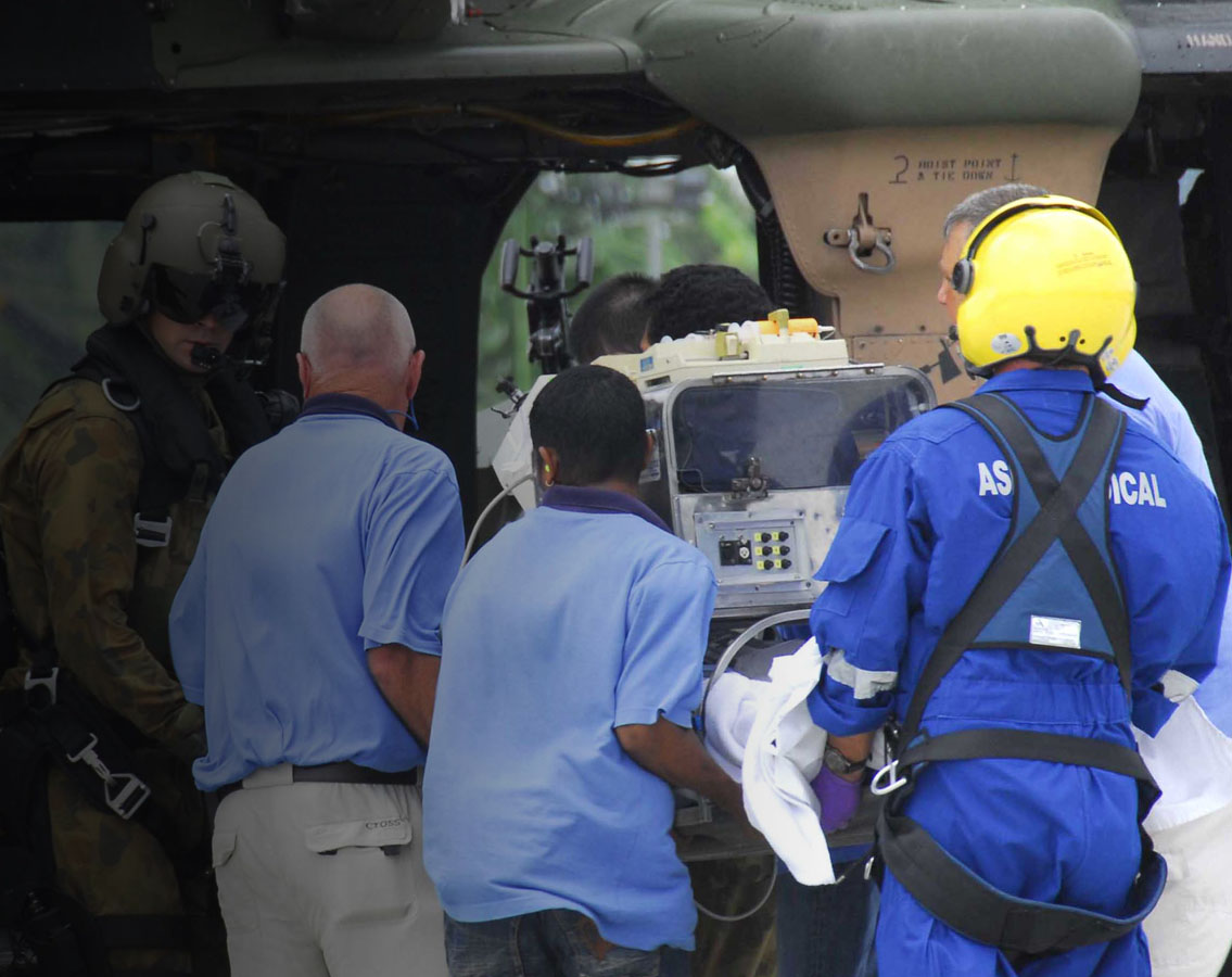 Image shows an Aspen Medical team loading a patient into an aircraft with military involvement.