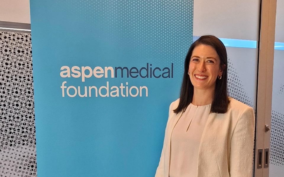 Woman standing beside a branded company banner