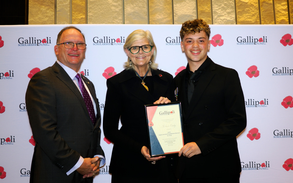 Student receiving award from Governor General against a branded backdrop