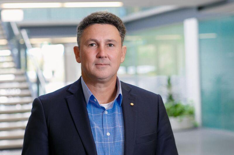 A professional portrait of Aspen Medical's Executive General Manager of International Operations in a modern office setting.