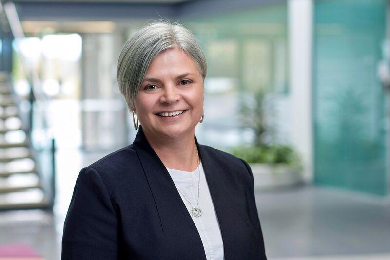 A professional portrait of Aspen Medical's Chief Medical Officer in a modern office setting.