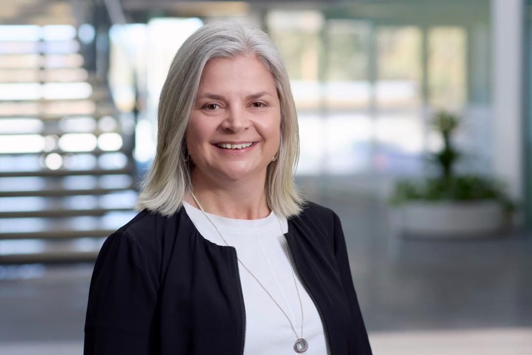 A professional portrait of Aspen Medical's Chief Medical Officer in a modern office setting.