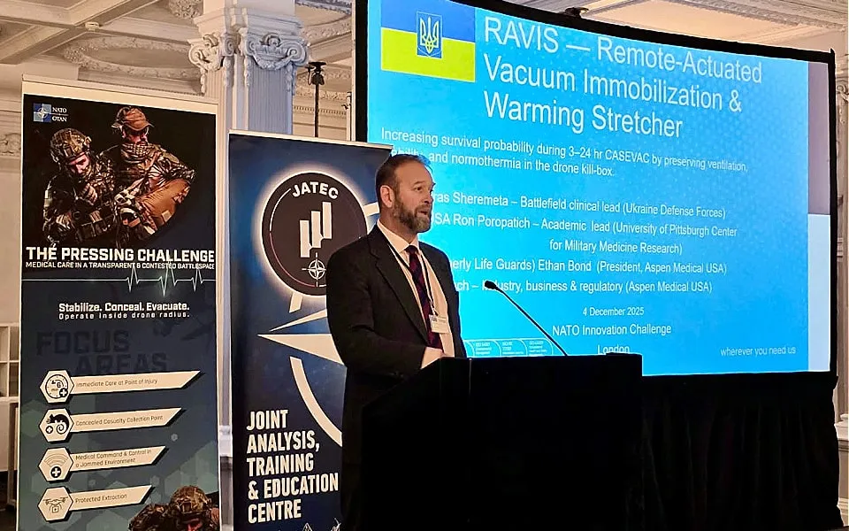 Man standing at podium in front of large screen giving presentation