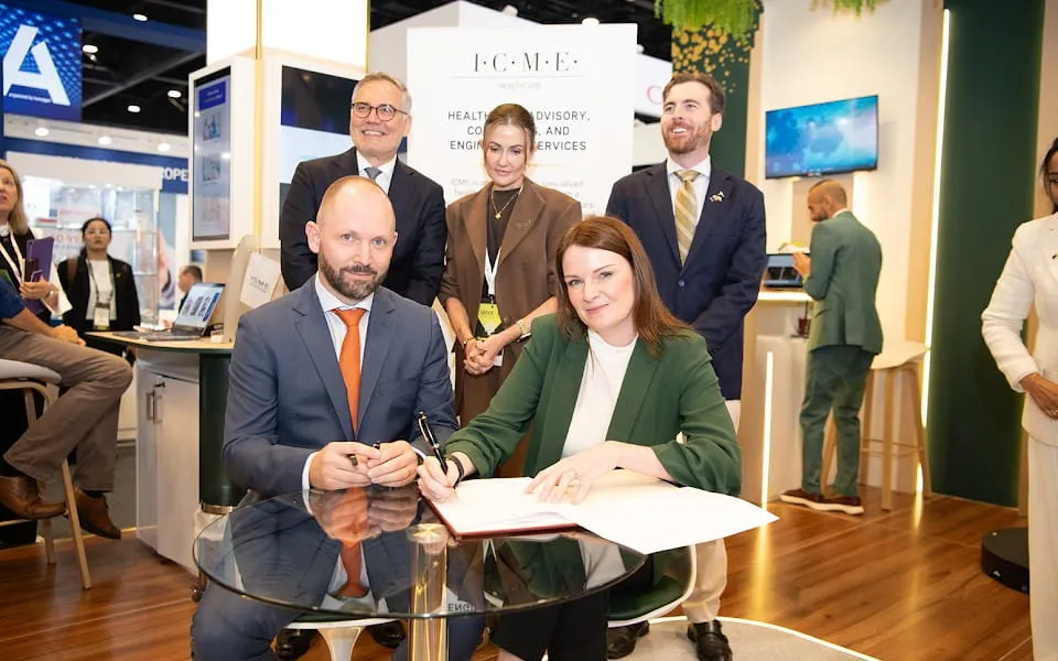 Executive teams standing and sitting at a signing ceremony at an expo