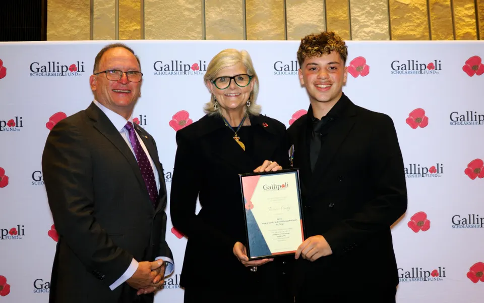 Student receiving award from Governor General against a branded backdrop